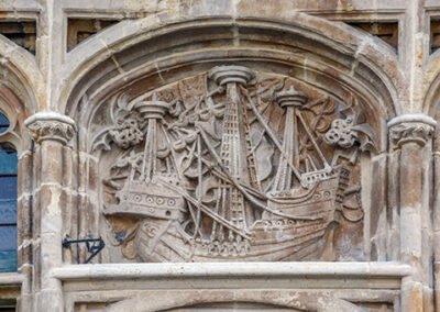 Stone relief carving of a medieval sailing ship on the facade of the Ghent Free Boatmen's Guild House (Gildenhuis van de Vrije Schippers) in Ghent, Belgium. The carving depicts a type of medieval commerce ship, highlighting the importance of the wool trade to the city's wealth in the late medieval period.